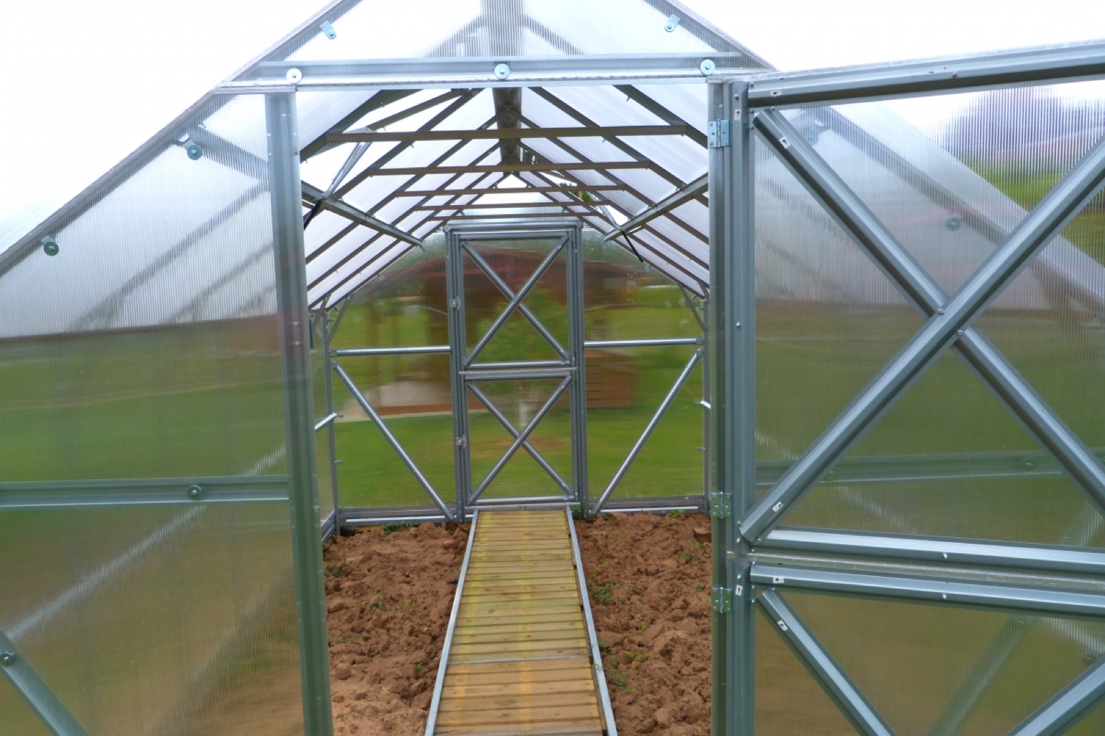Inside the growing aisle looking toward the end door, with both roof vents propped open