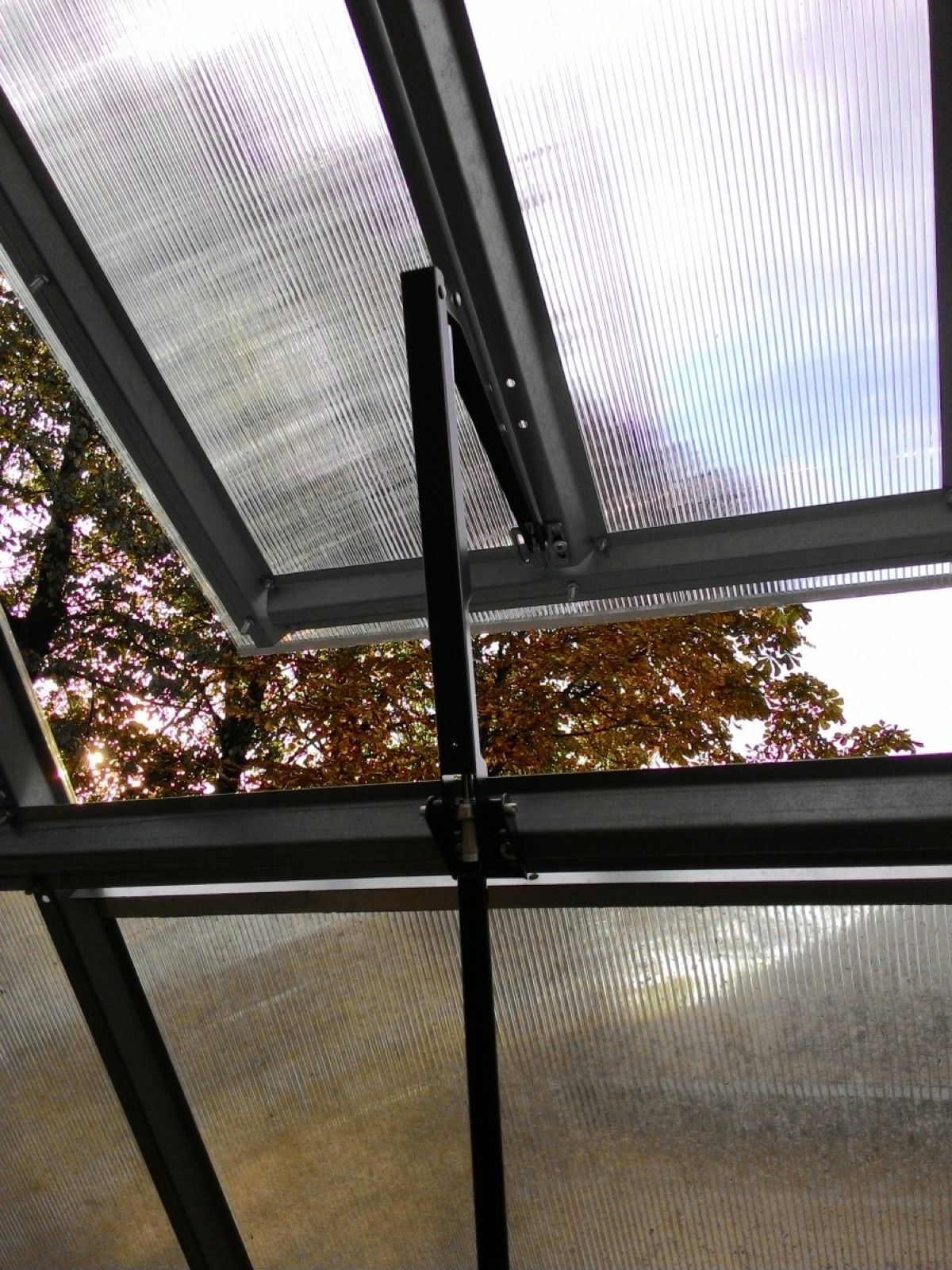Close-up of the roof vent hinge and the channeled structure of the polycarbonate panels